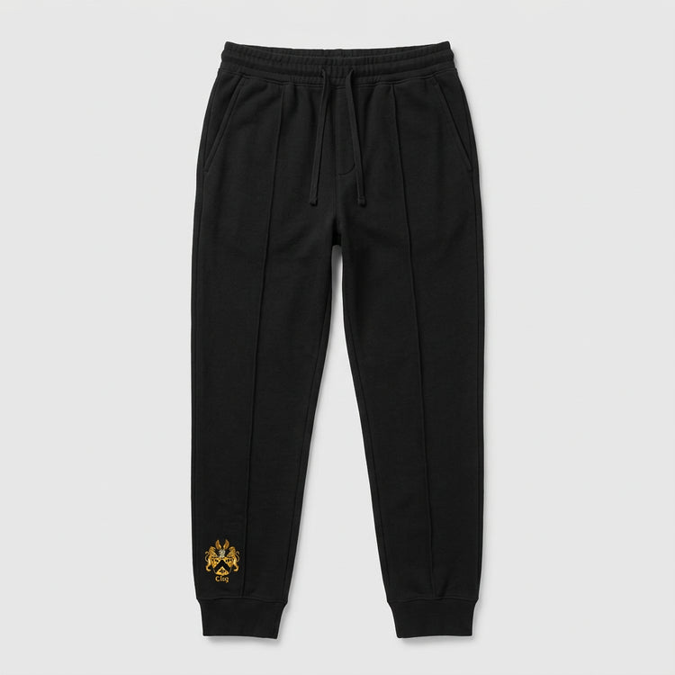 Black French terry tailored sweatpants with drawstring waist, ribbed cuffs, pressed creases and small gold crest